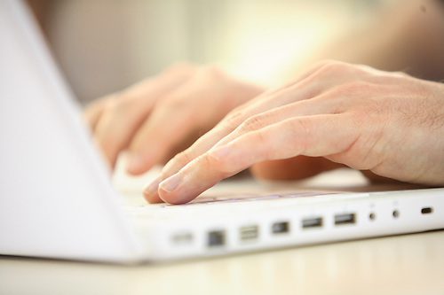 person typing on a laptop computer